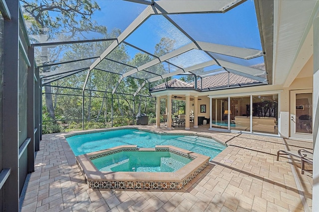 view of pool with a pool with connected hot tub, a lanai, and a patio area