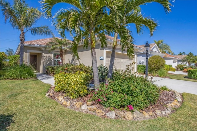 view of side of property with driveway, an attached garage, stucco siding, a tile roof, and a lawn