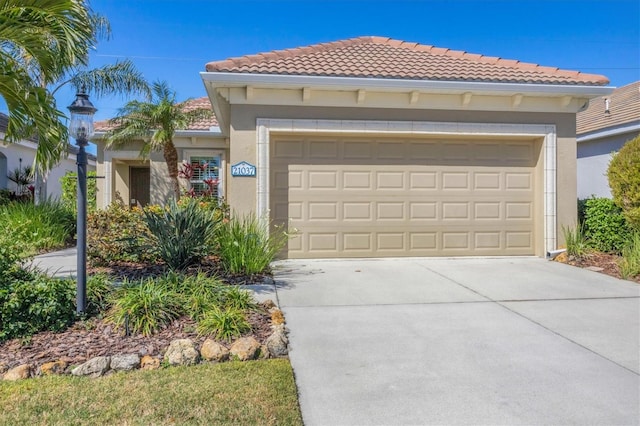 view of front of property with stucco siding, driveway, an attached garage, and a tile roof