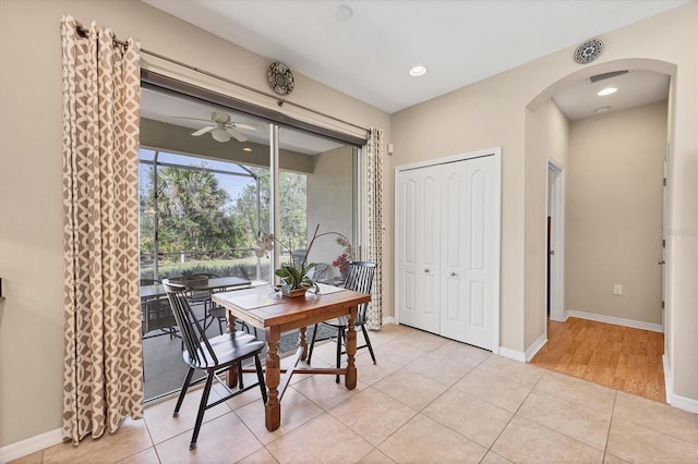 dining space featuring light tile patterned floors, a ceiling fan, baseboards, recessed lighting, and arched walkways