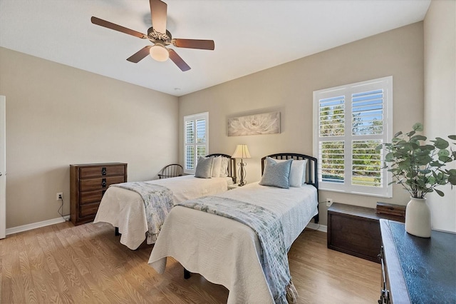 bedroom featuring baseboards, ceiling fan, and light wood finished floors