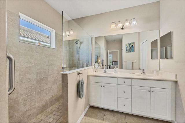 bathroom with a sink, double vanity, tile patterned flooring, and walk in shower