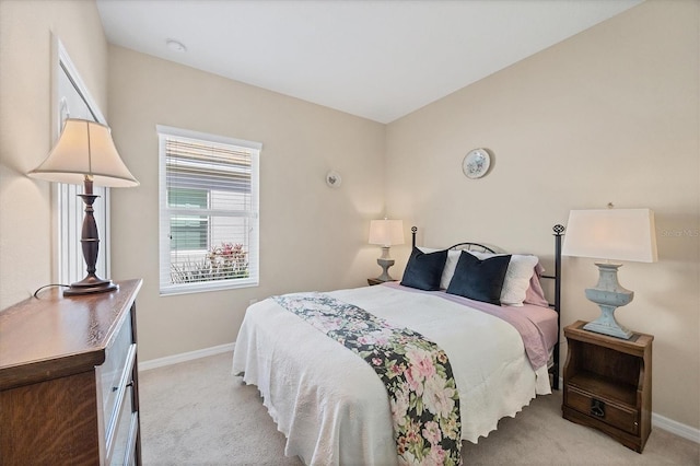 bedroom with light colored carpet and baseboards