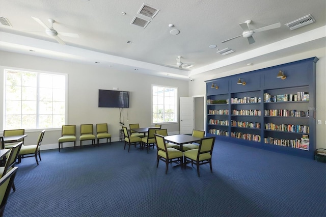 living area featuring visible vents, baseboards, and ceiling fan