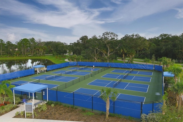 view of sport court with a water view and fence