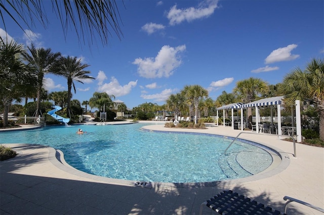 pool featuring a patio, a pergola, and a water slide