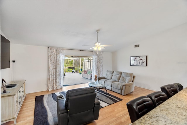 living area with ceiling fan, visible vents, lofted ceiling, and light wood-style flooring