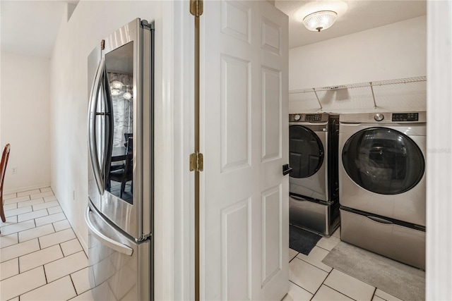 laundry room with light tile patterned floors and washer and clothes dryer