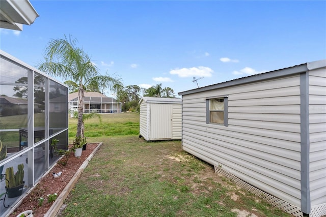 view of yard featuring a lanai, a shed, and an outdoor structure