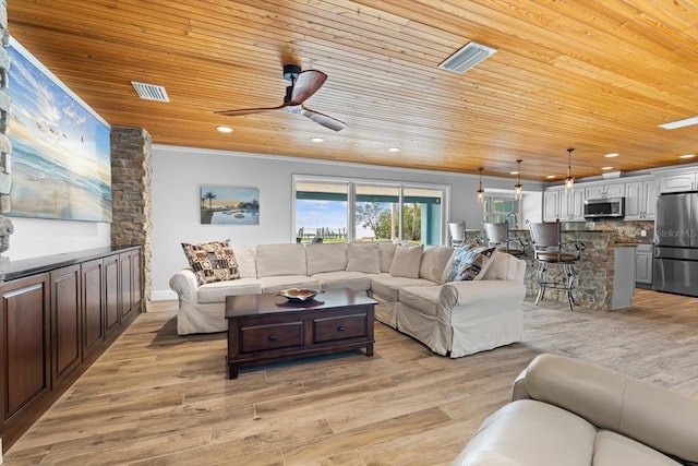 living room featuring visible vents, light wood-style floors, wood ceiling, and crown molding