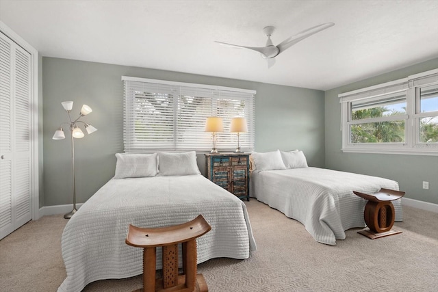 carpeted bedroom with a ceiling fan, baseboards, and a closet