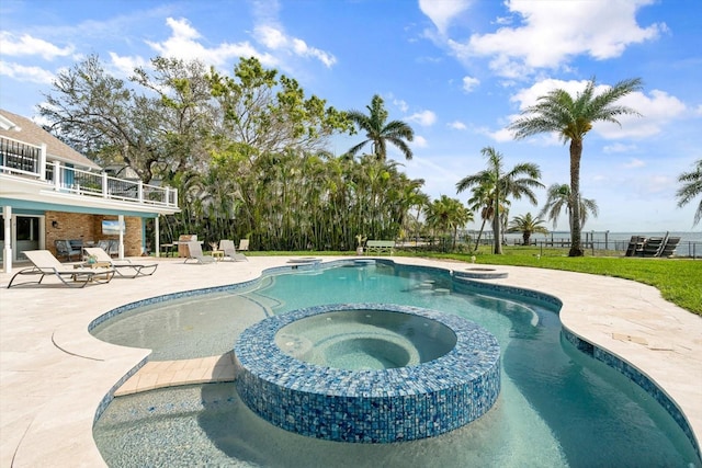 view of swimming pool with a pool with connected hot tub, a patio, and fence