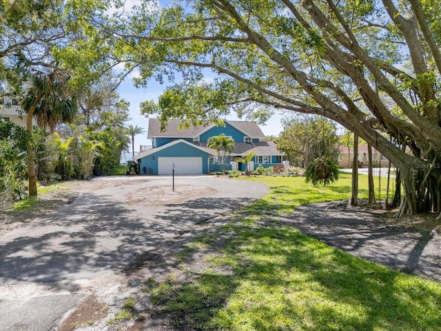 7330 Westmoreland Dr, Sarasota, FL 34243 - view of front of house featuring aphalt driveway, a garage, and a front lawn