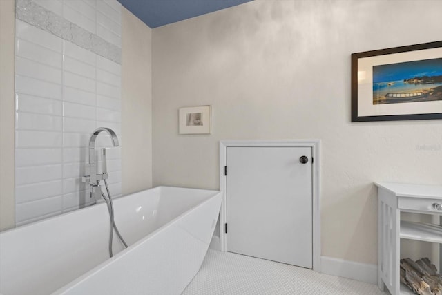 bathroom featuring baseboards and a freestanding bath