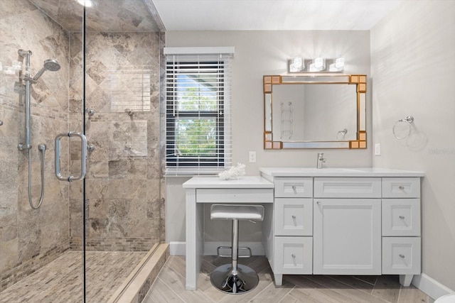 bathroom featuring vanity, a shower stall, and baseboards