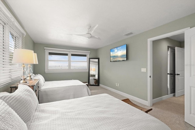 bedroom with visible vents, baseboards, light carpet, and ceiling fan