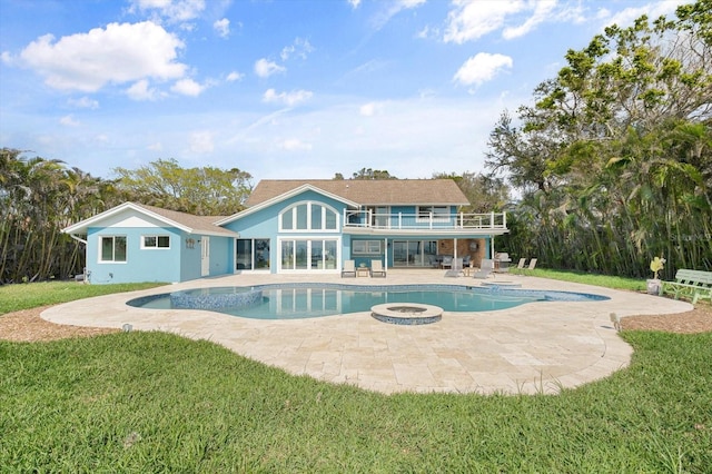 back of house with a balcony, an outdoor pool, stucco siding, a patio area, and a lawn