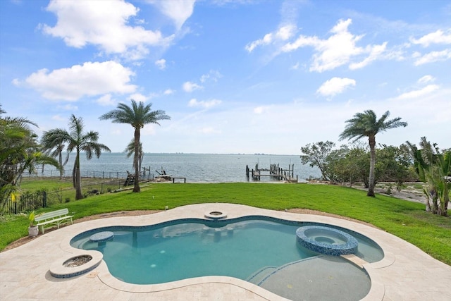 view of pool with a yard, a water view, a dock, and fence