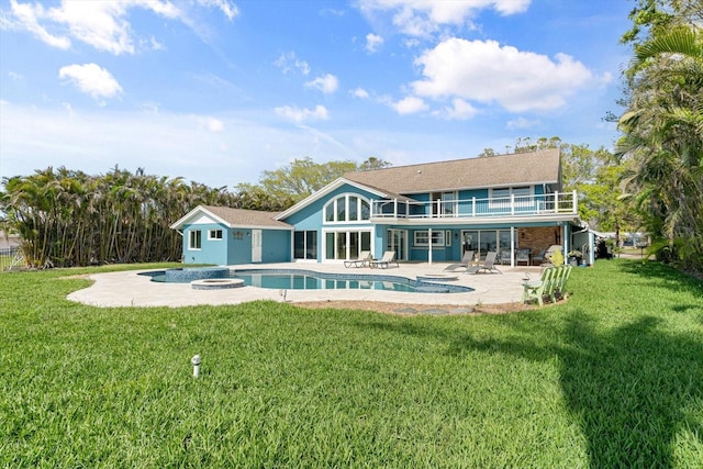 rear view of property with a jacuzzi, a lawn, a balcony, an outdoor pool, and a patio