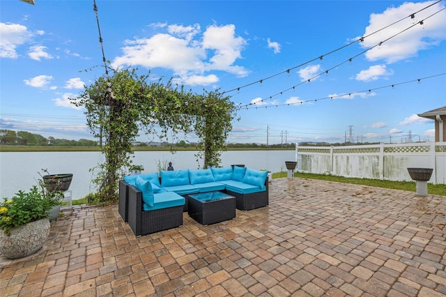 view of patio with a water view, outdoor lounge area, and fence