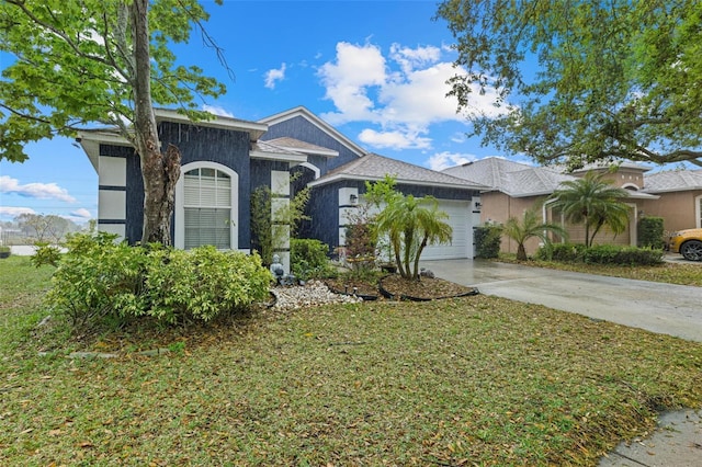 view of front of property with stucco siding, a front yard, an attached garage, and driveway