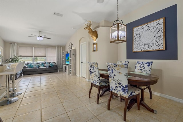 dining area with visible vents, a ceiling fan, arched walkways, light tile patterned floors, and baseboards