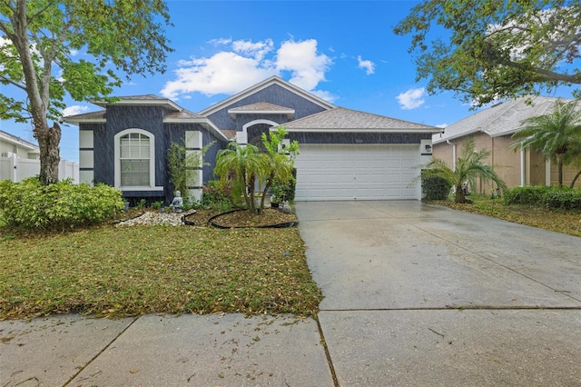 ranch-style house featuring stucco siding, an attached garage, driveway, and fence