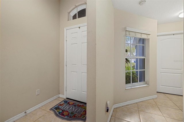 tiled foyer featuring baseboards