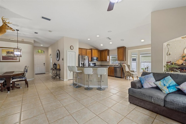 living area featuring light tile patterned flooring, visible vents, recessed lighting, and lofted ceiling