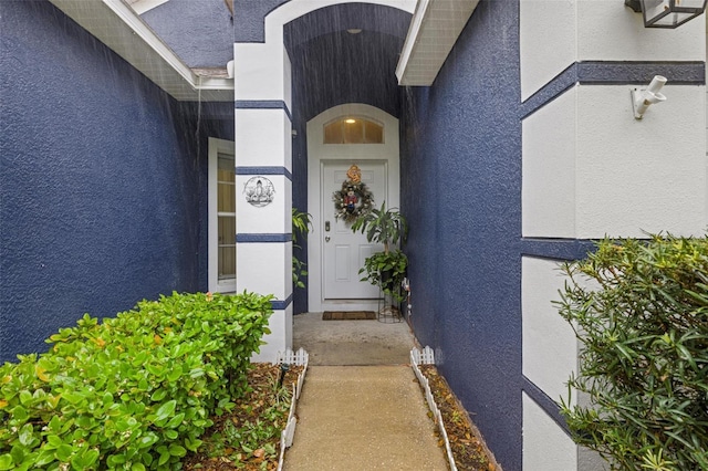 property entrance with stucco siding