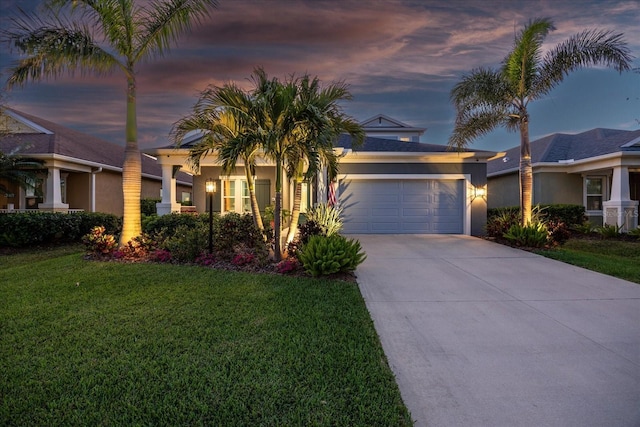 view of front of house with a garage, stucco siding, concrete driveway, and a yard