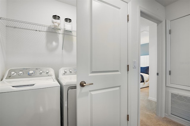 laundry area with visible vents, separate washer and dryer, and light colored carpet