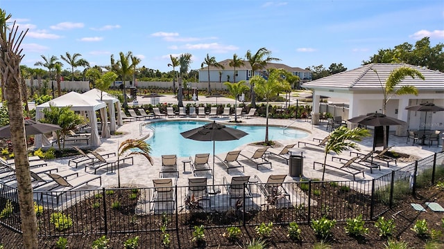 community pool with a patio area and fence