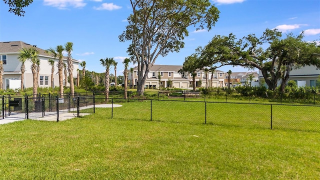 view of home's community with a residential view, a lawn, and fence