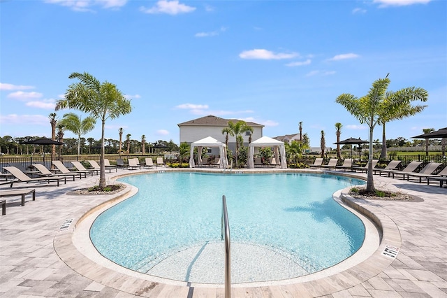 pool with a gazebo, a patio area, and fence