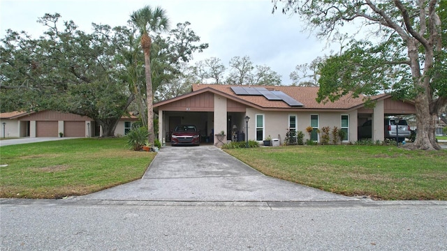 single story home featuring solar panels, a front lawn, a garage, and stucco siding