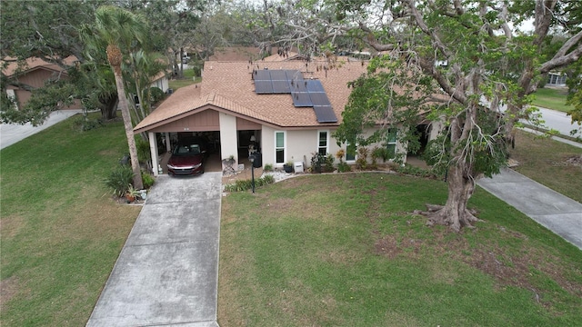 view of front of home featuring solar panels, stucco siding, a shingled roof, a front lawn, and concrete driveway