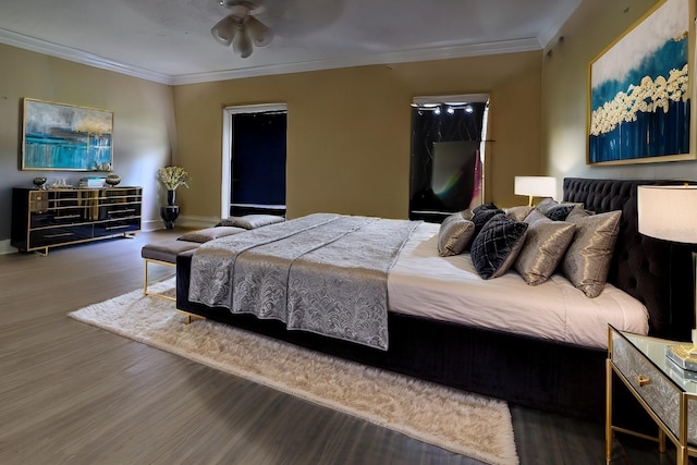 bedroom featuring ceiling fan, baseboards, wood finished floors, and ornamental molding