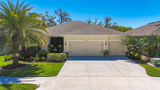 view of front of property featuring a front lawn, concrete driveway, roof with shingles, stucco siding, and an attached garage