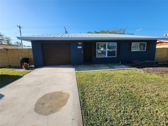 view of front of home with an attached garage, concrete driveway, a front yard, and fence