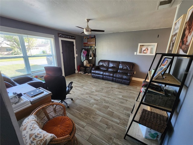 office space featuring wood finished floors, a ceiling fan, visible vents, and a textured ceiling