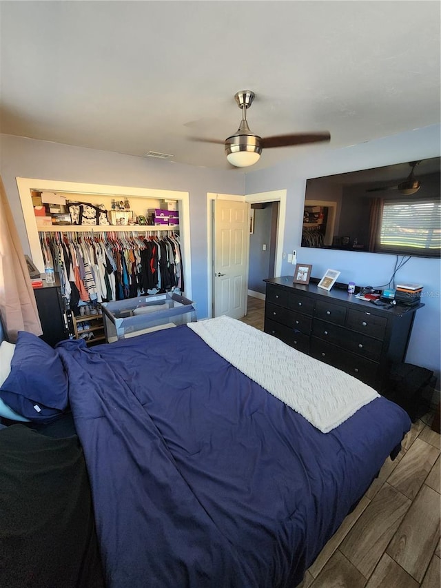 bedroom with a closet, a ceiling fan, and wood finished floors