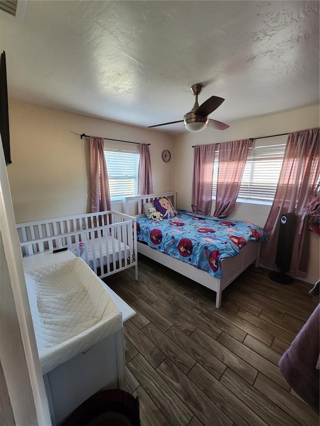 bedroom featuring a textured ceiling, a ceiling fan, and wood finished floors