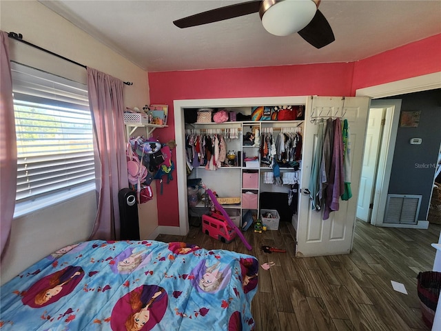 bedroom with ceiling fan, visible vents, a closet, and wood finished floors