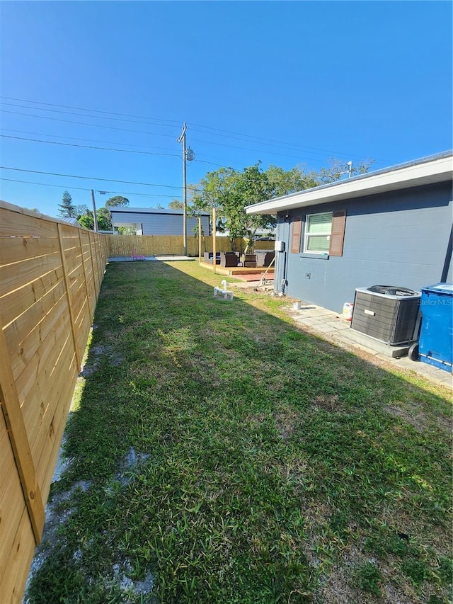 view of yard with cooling unit, a fenced backyard, and a patio