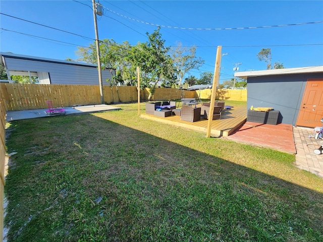 view of yard with a deck, outdoor lounge area, and a fenced backyard