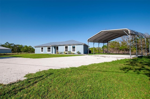 view of front of house featuring a carport, gravel driveway, and a front lawn