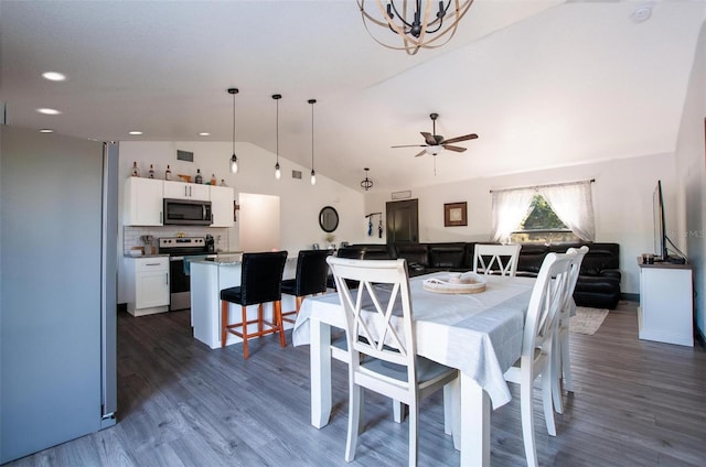 dining space with ceiling fan with notable chandelier, lofted ceiling, recessed lighting, and wood finished floors