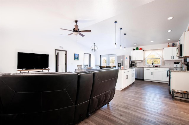 living room with a ceiling fan, recessed lighting, dark wood-type flooring, vaulted ceiling, and french doors