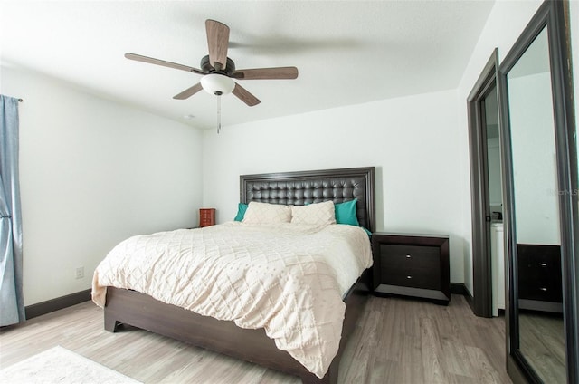 bedroom with baseboards, wood finished floors, and a ceiling fan